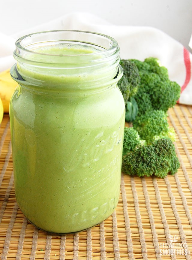 Apple broccoli ginger smoothie in glass mason jar next to fresh broccoli