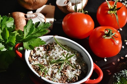 rice in dish next to fresh tomatoes, mushrooms, and garnish