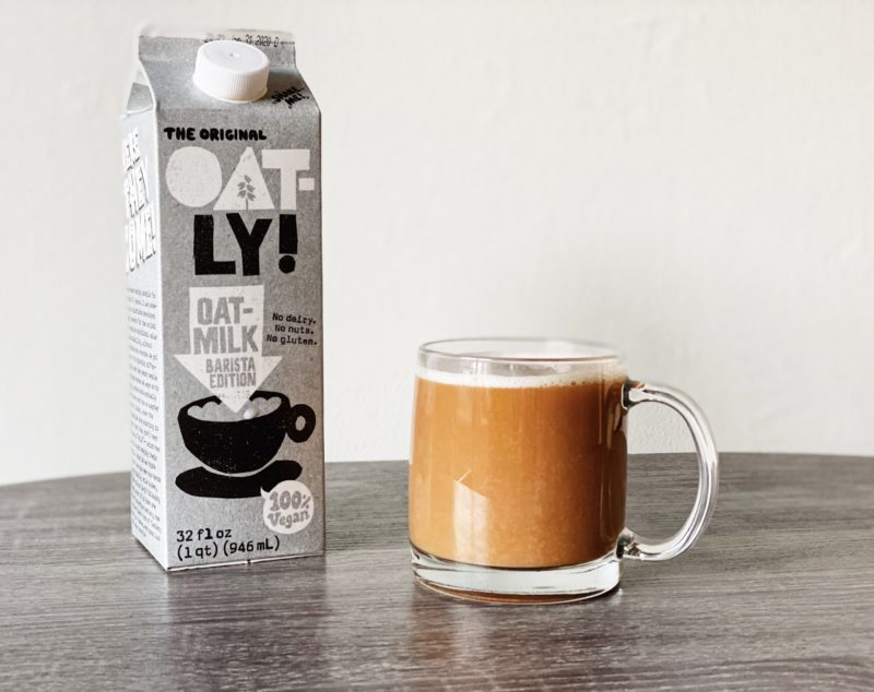 Oat-ly milk jug next to coffee mug