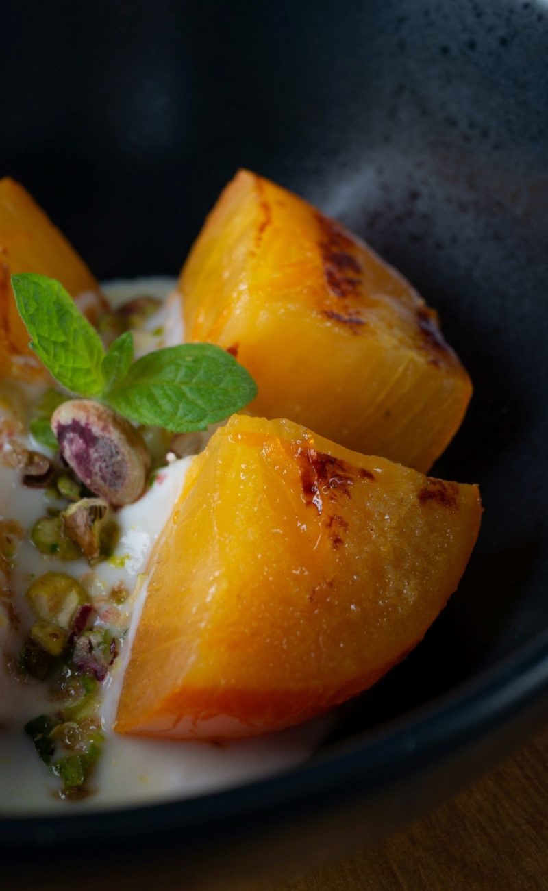 Cut peaches in a bowl with yogurt and nuts