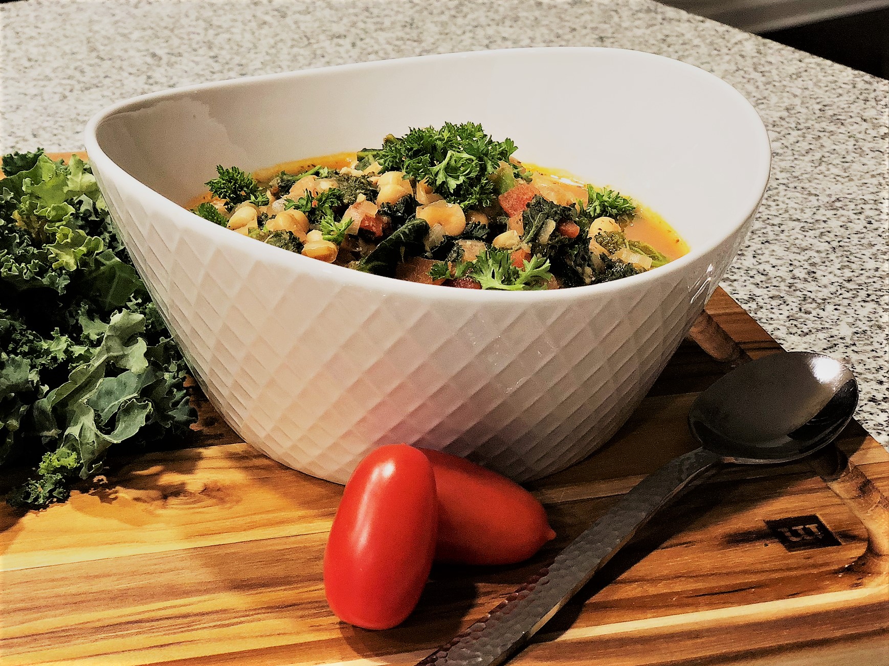 Kale and Bean Soup, in white bowl with spoon and garnish