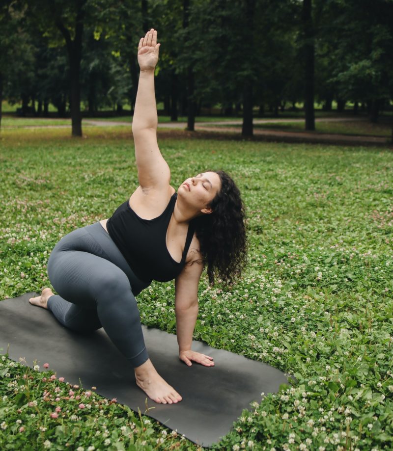 Woman doing yoga outside in park