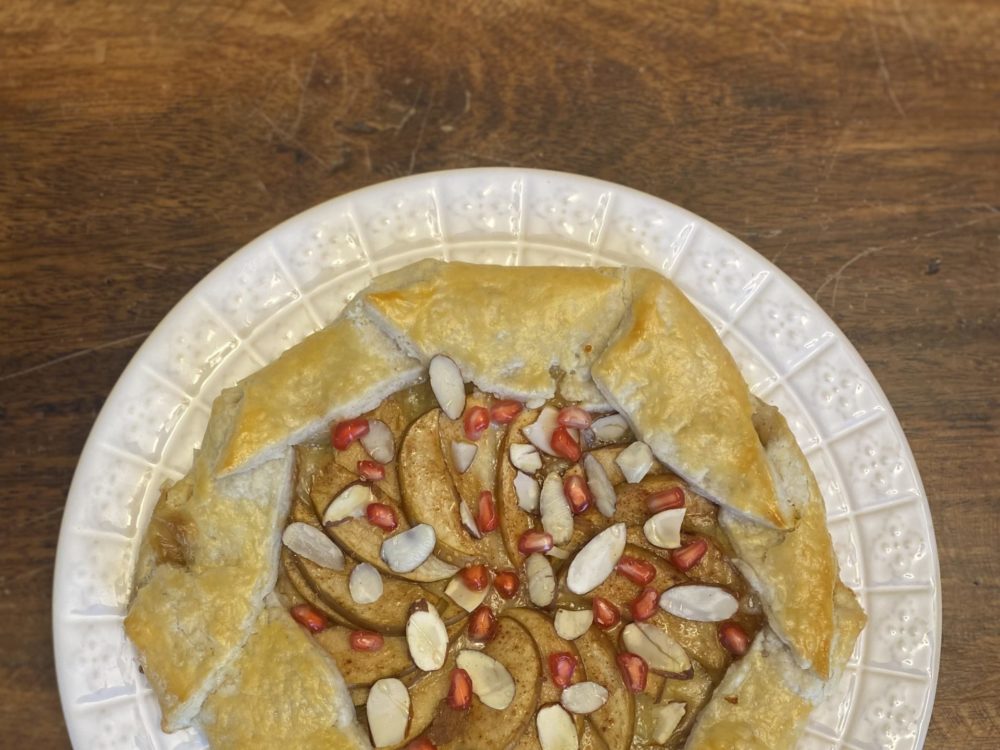 Apple Galette on plate with almond slices and pomegranate seeds on top