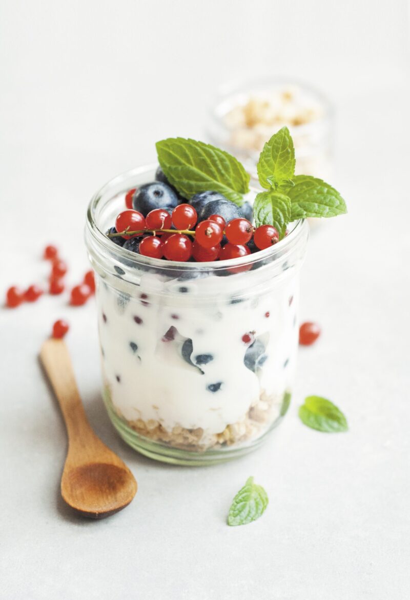 small jar filled with granola, yogurt and berries
