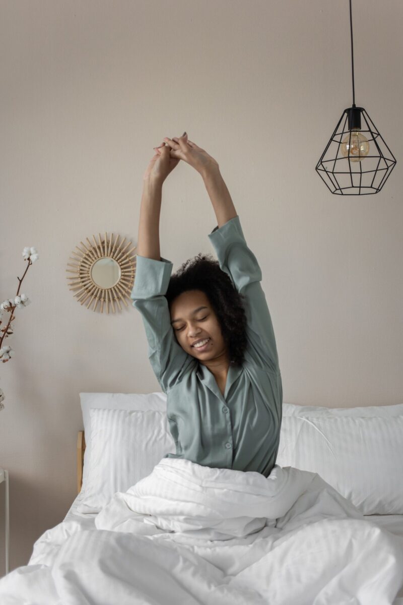 Woman sitting in bed stretching