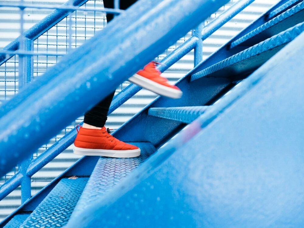 person with orange sneakers walking up stairs