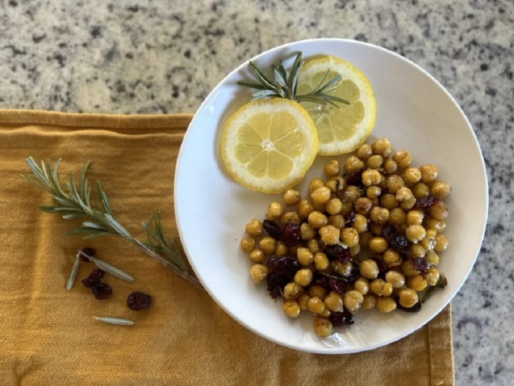 Roasted chickpeas with rosemary on plate with lemon slices