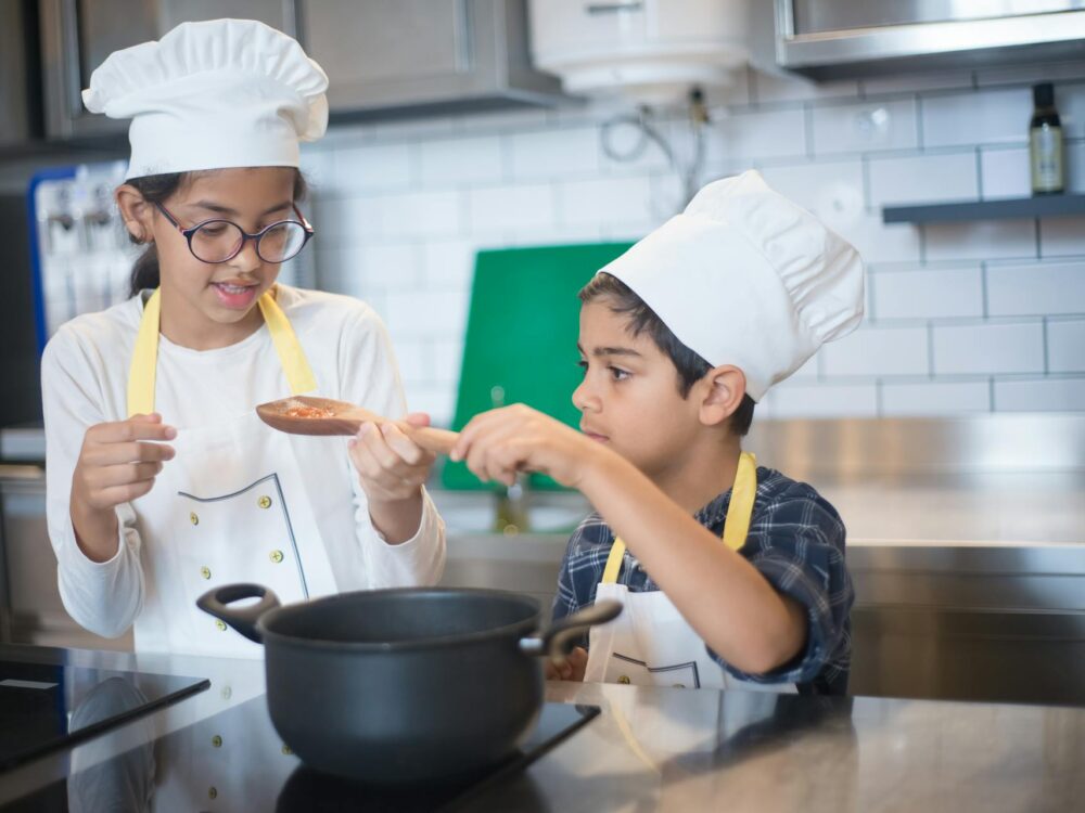 two children cooking with chef's hats on