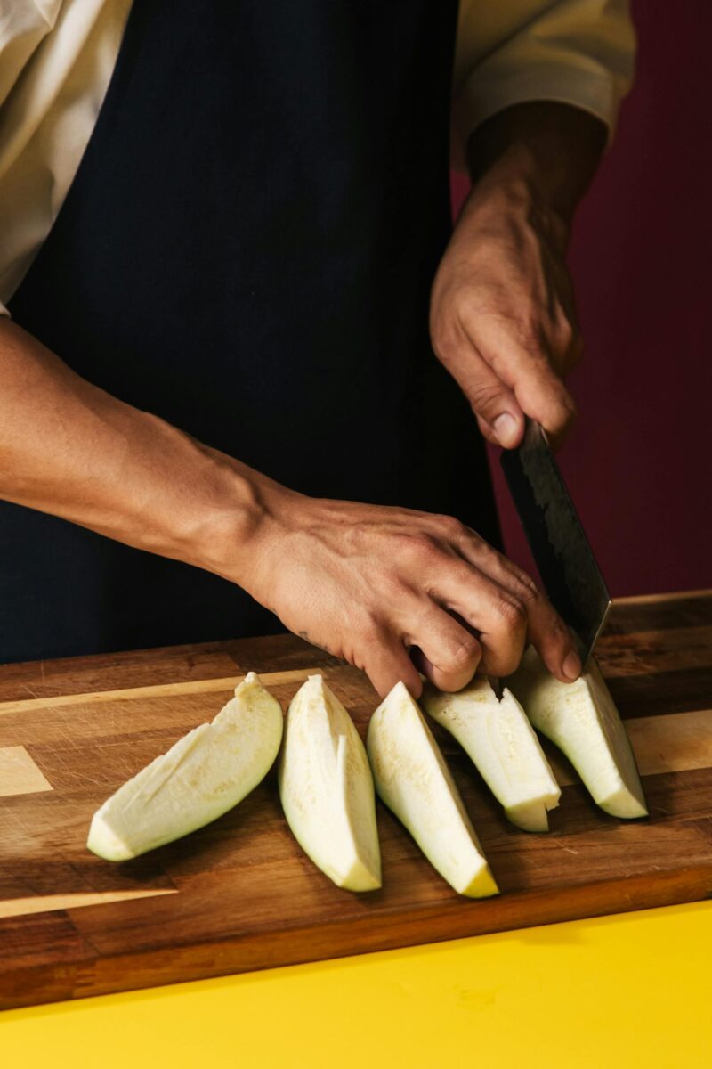 person cutting eggplant
