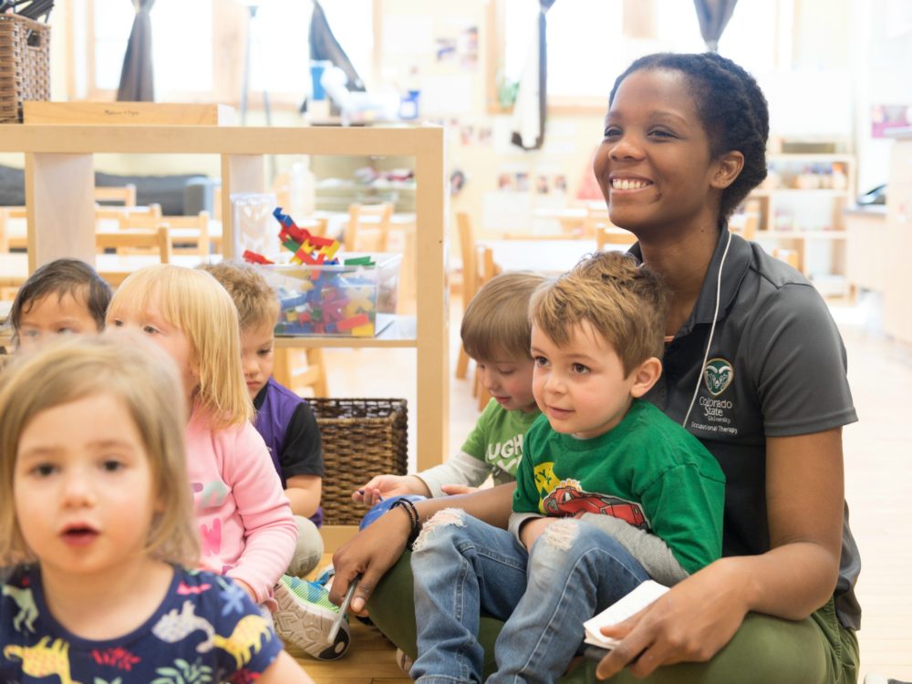 OT student sitting with toddlers in the Early Childhood Center