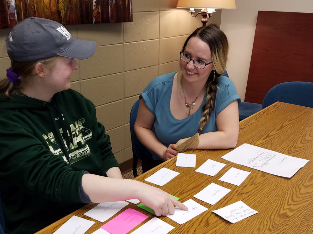 Mentor helping student study with flashcards