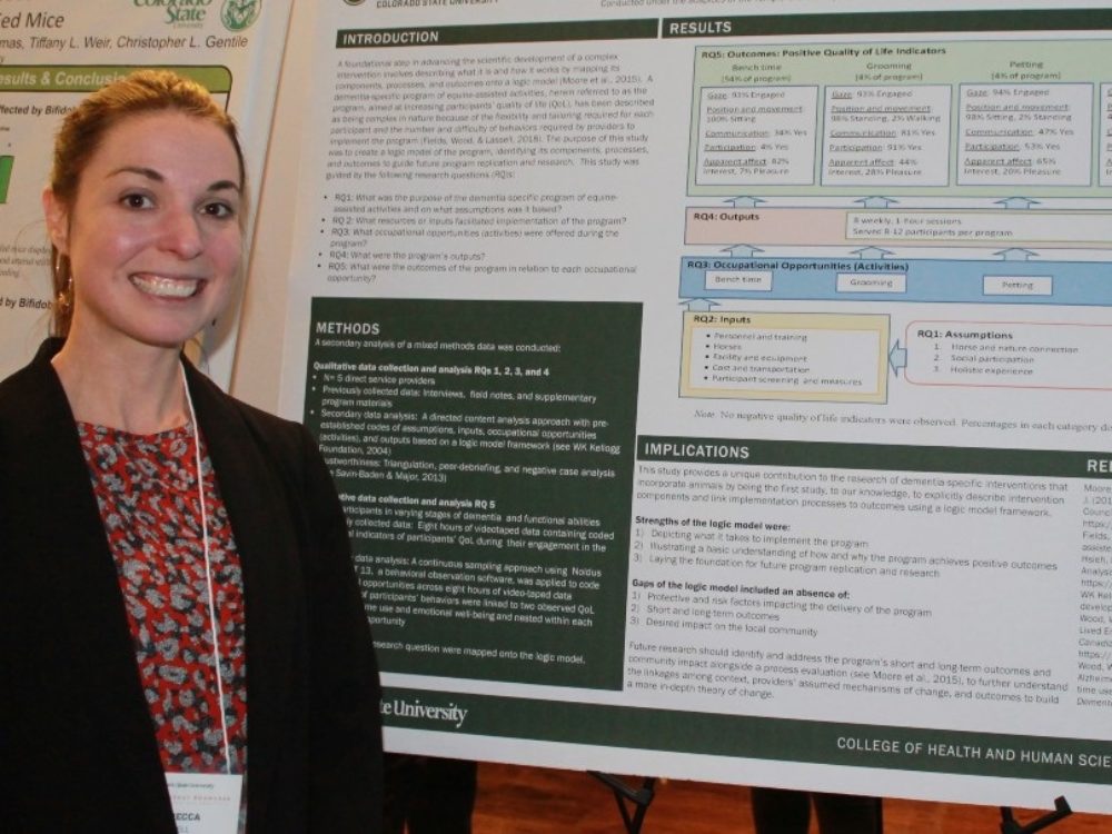 Rebecca Lassell standing next to her research poster