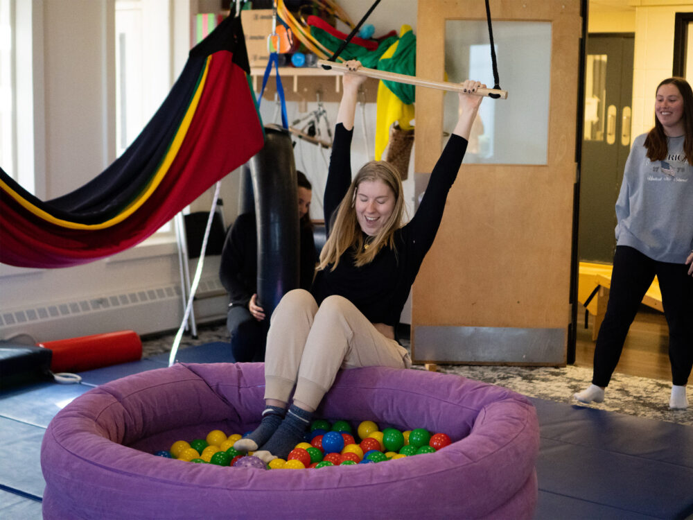 Students exploring the space for children's therapy with swings and a ball pit