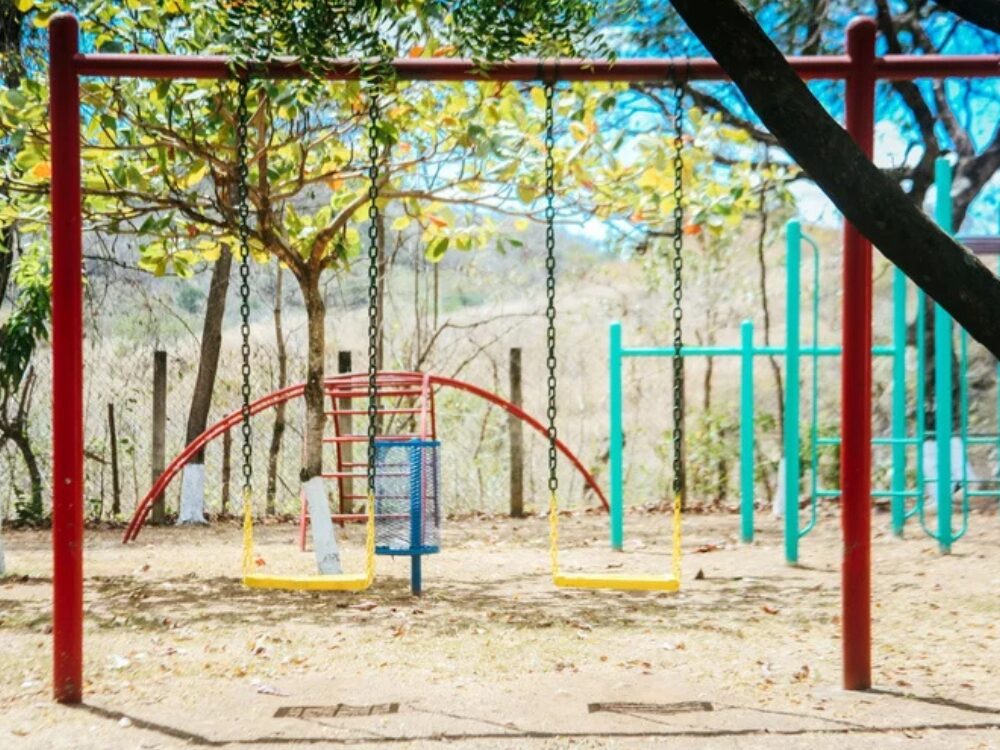 An empty swing set at a park on a sunny day