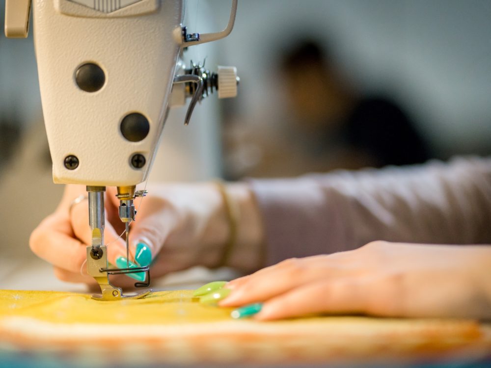 A close up shot of a student hands using a sewing machine in the Prototyping Lab