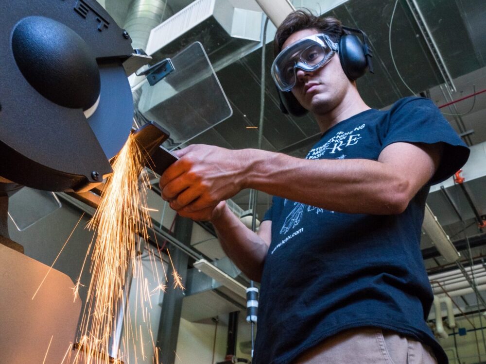 A student using a grinder in the Metal Lab