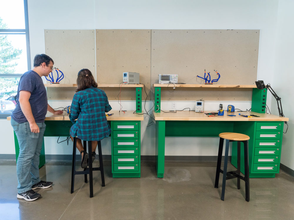 Two students work together at the electronic benches in the Prototype Lab