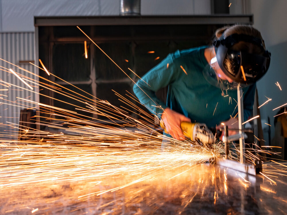 A student creates sparks using an angle grinder in the Metals Lab