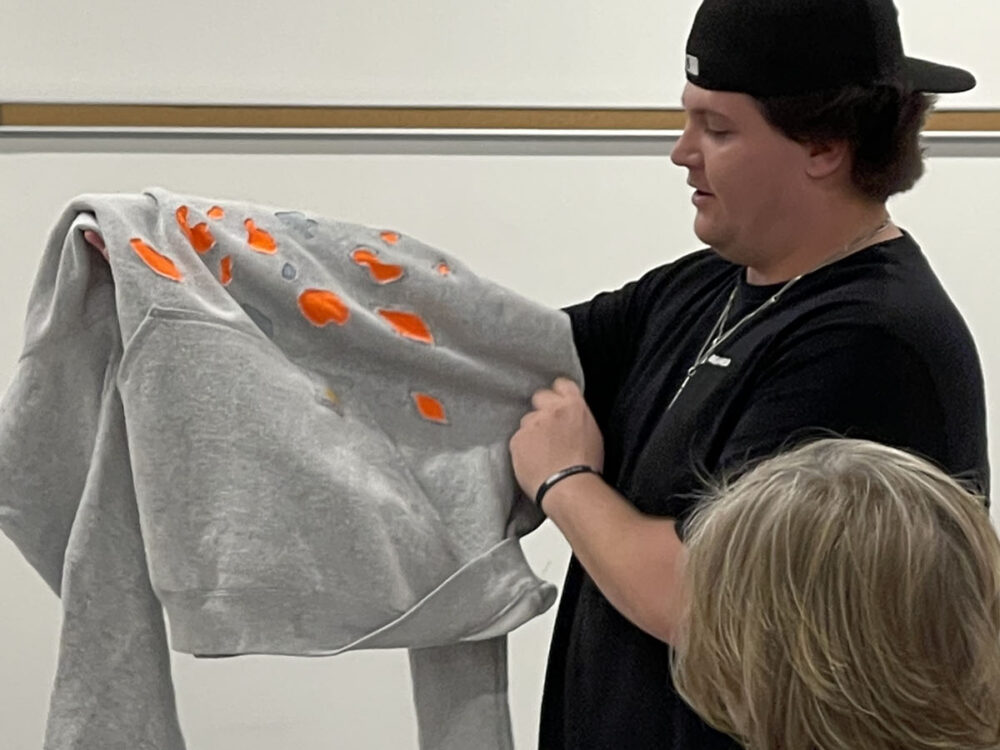 A student shows his apparel design during a design thinking course at the RDC