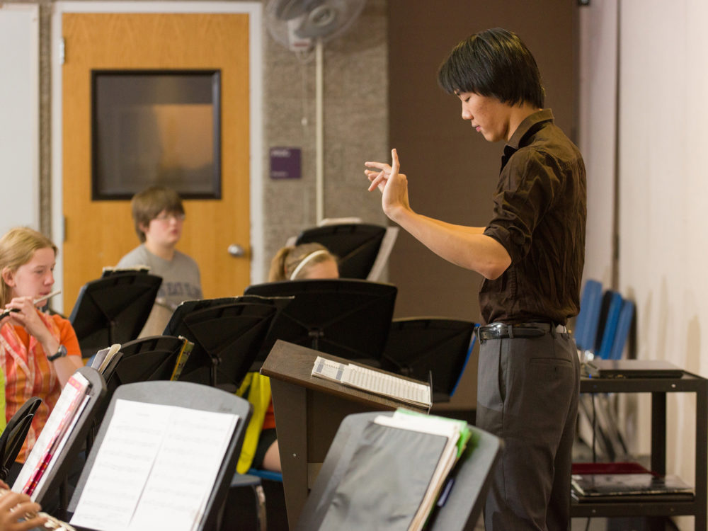Student teacher conducts middle school band students