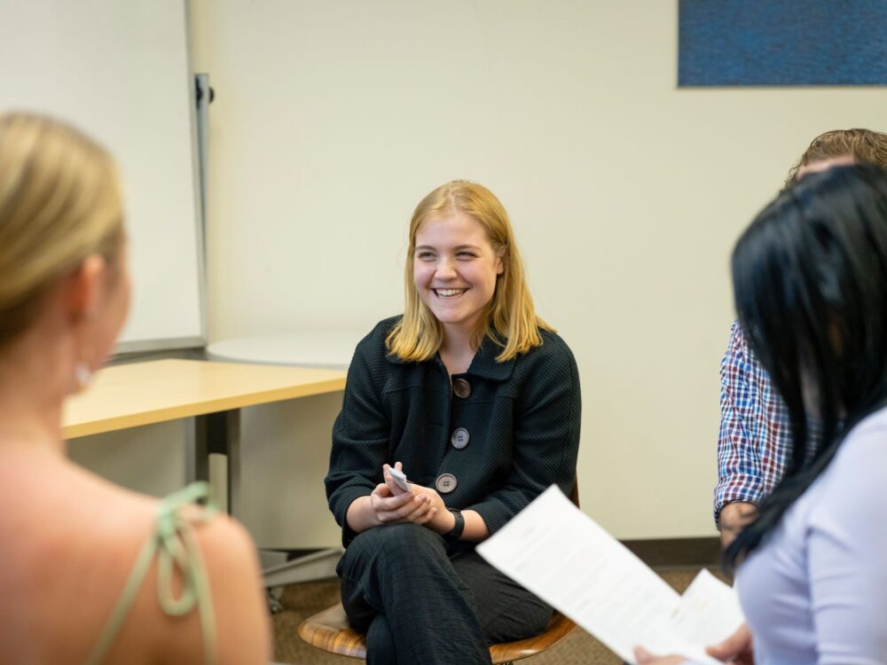 a student smiles during a group activity in a BSW class.