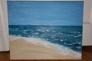An image of a painting on canvas of a beach with ocean water crashing against the shore.