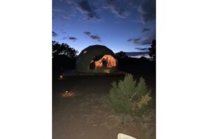 A sky dome in an empty field on a summer evening.