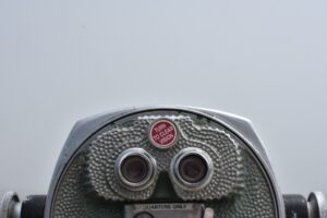 An image of a viewfinder on a pier with text above the binoculars that reads "Turn to clear vision"