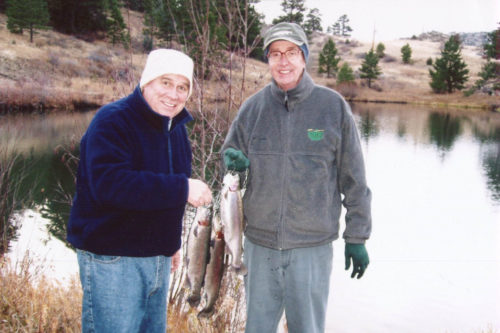 Grant with a friend holding fish they caught