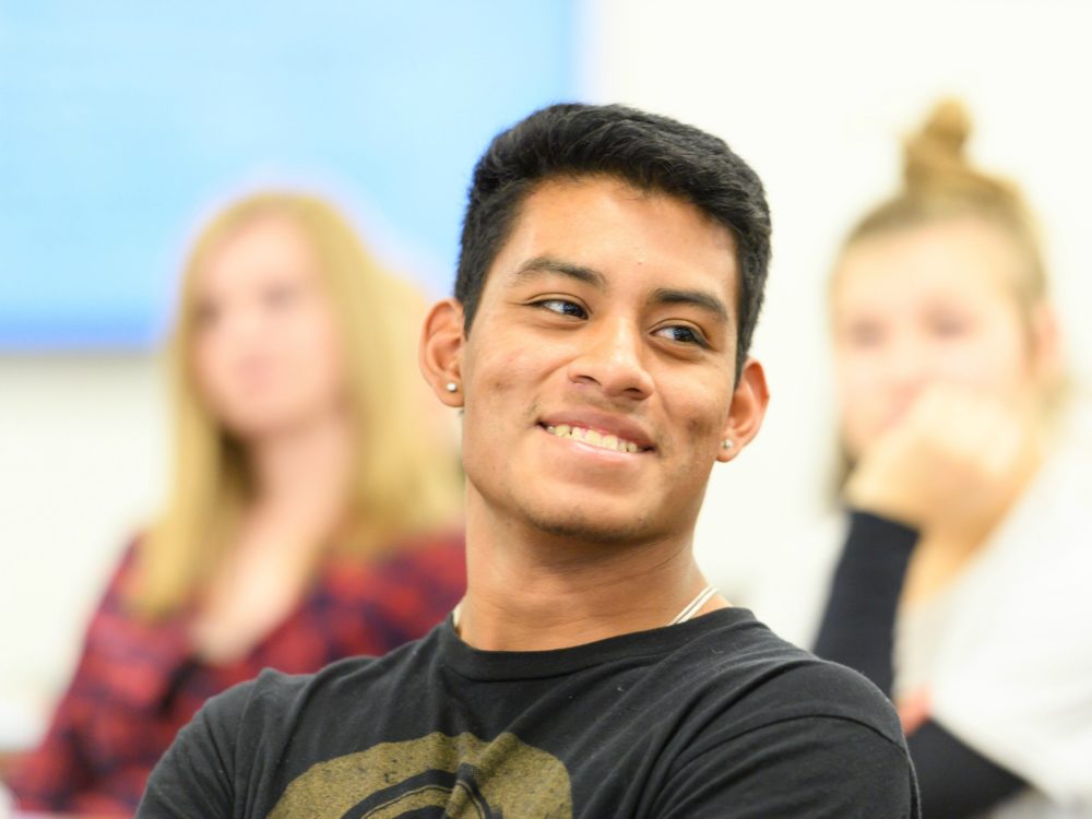 Student in a classroom smiling