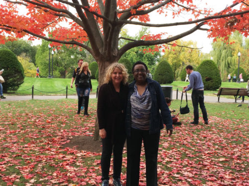 Cheryl Presley and Victoria Keller stand beneath an autumnal, red-leaved tree on a fall afternoon.