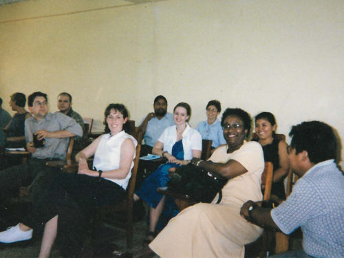Cheryl Presley smiles with a group of her colleagues in a classroom.