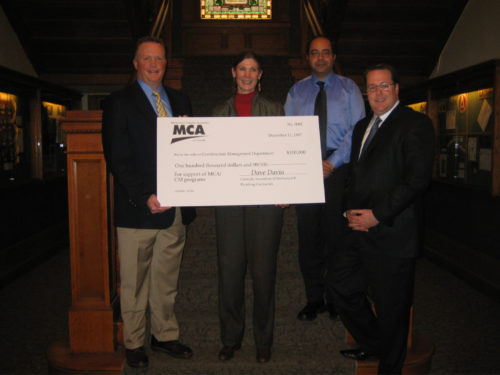 April Mason holds a large donation check with three of her colleagues.