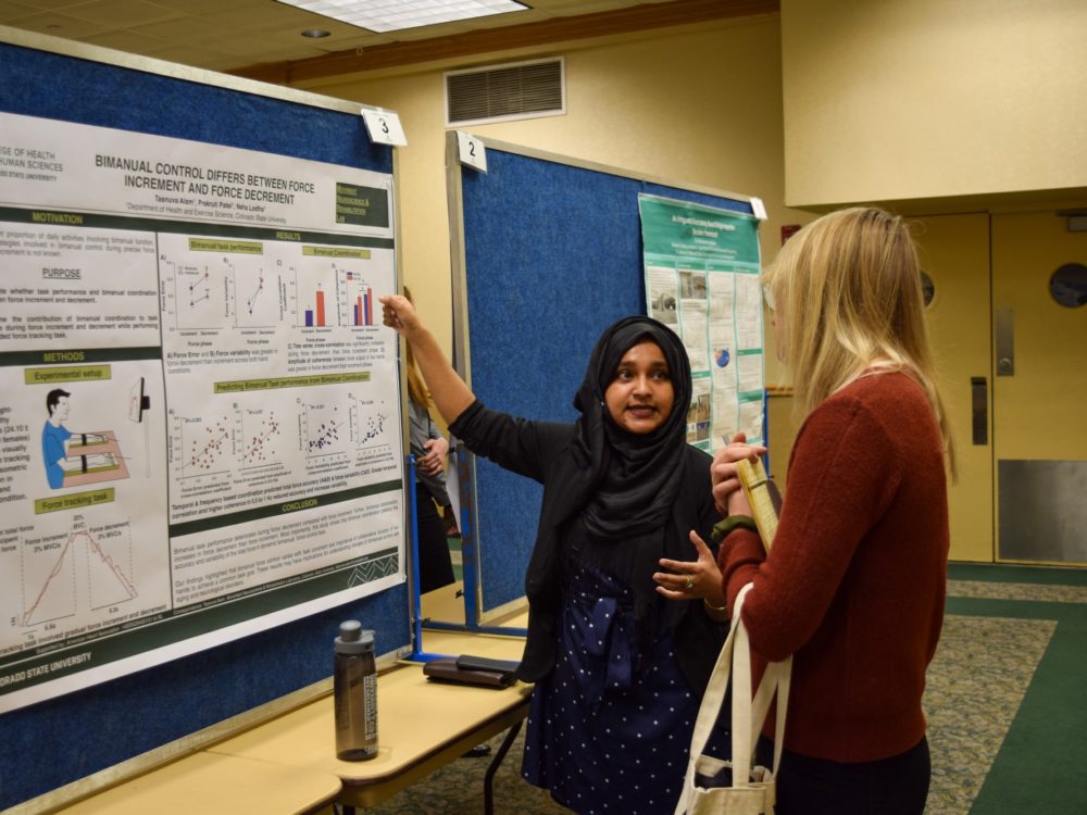 Graduate student explaining her research poster