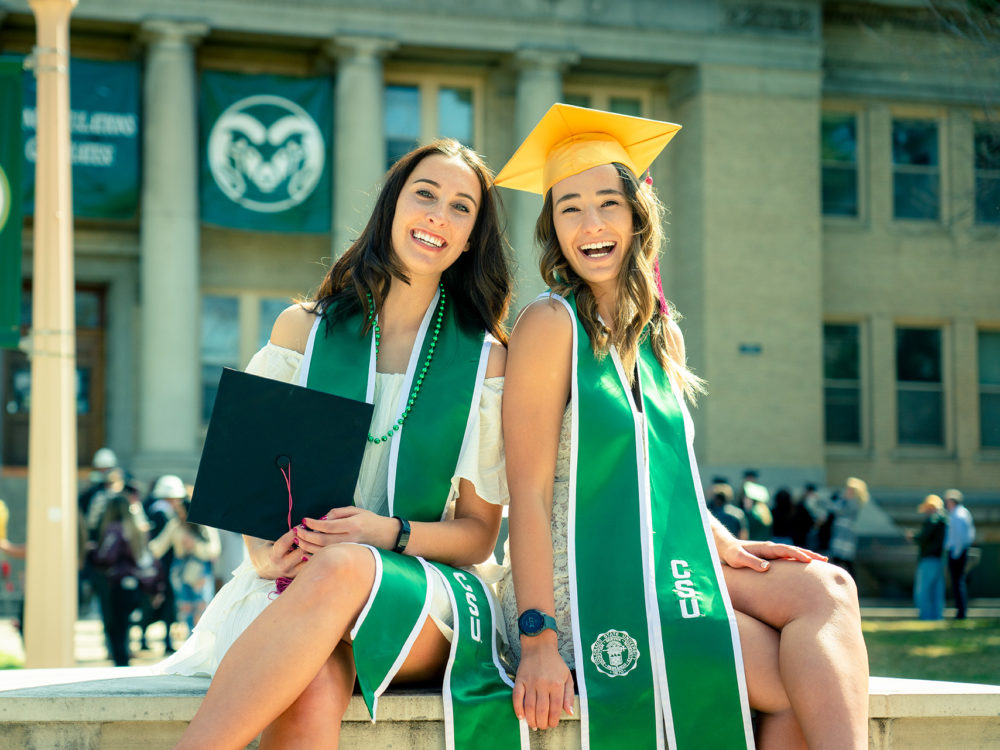 Two graduates with CSU stoles on the Oval