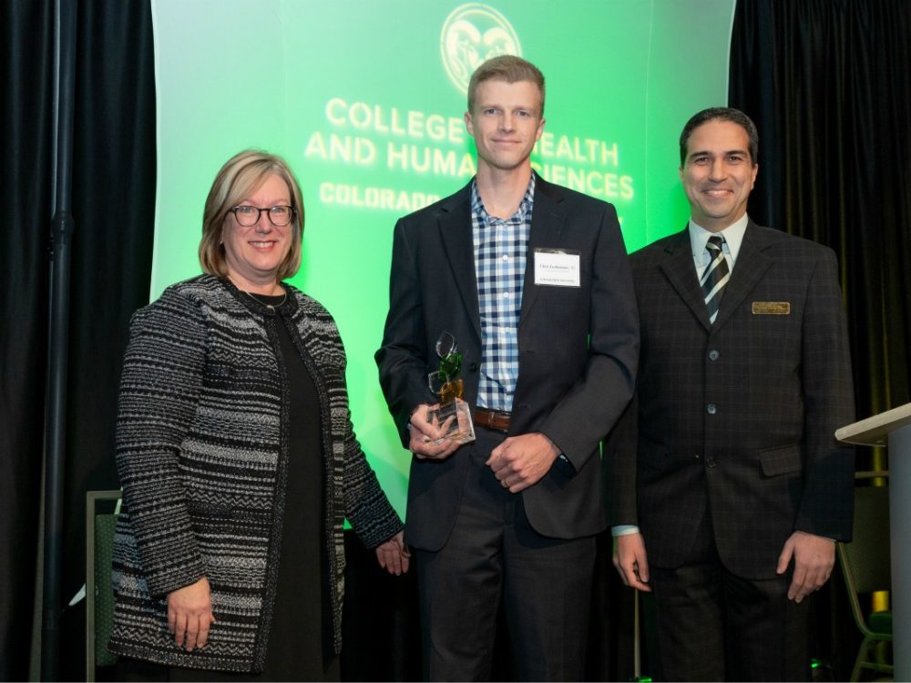 Dean Lise Youngblade (left) and Mehmet Ozbek (right) honor Chris Lierheimer (center) with 2019 CHHS Emerging Leader Alumnus Award