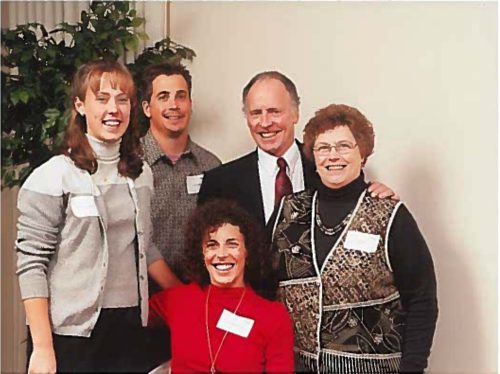 Kelly in an early scholarship event photo with her parents and two recipients