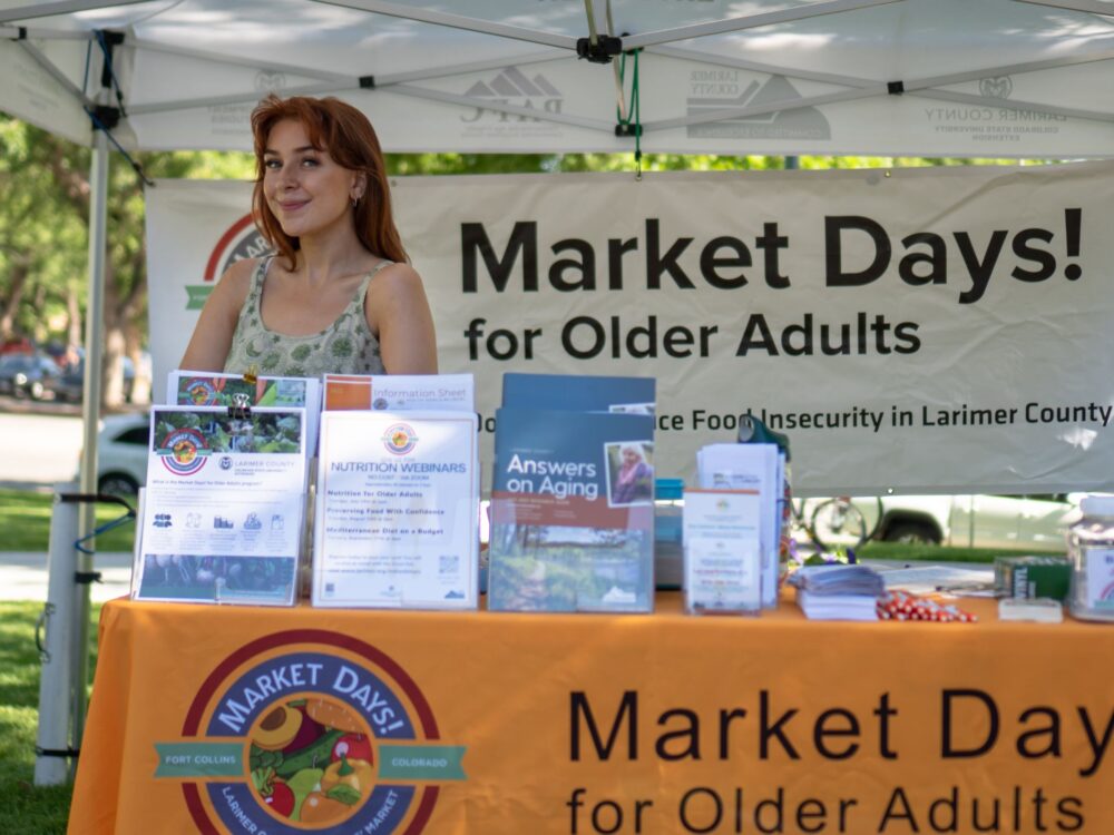 Jesse Whitcomb sits at the Market Days booth at the Larimer County Farmers' Market.