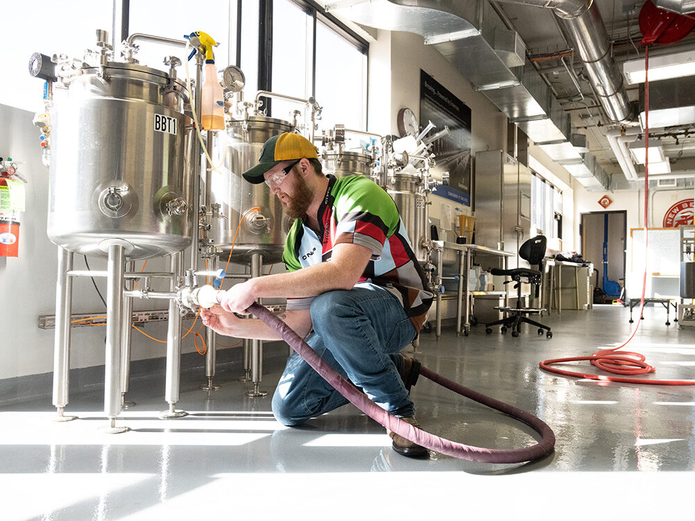 KC Lyons cleans brewery equipment at the end of the day. Food Science and Human Nutrition, March 9, 2023