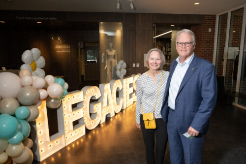 Jeff and Debbie McCubbin in front of large lighted letters reading Legacies