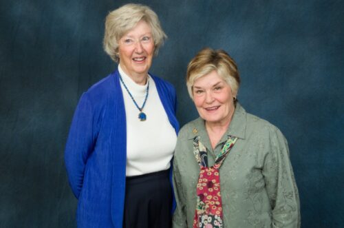 Janet Fritz and Jill Kreutzer in front of a backdrop
