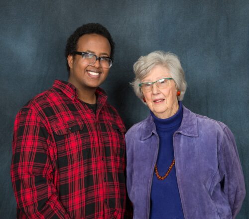 A scholarship student posing with Janet Fritz in front of a backdrop