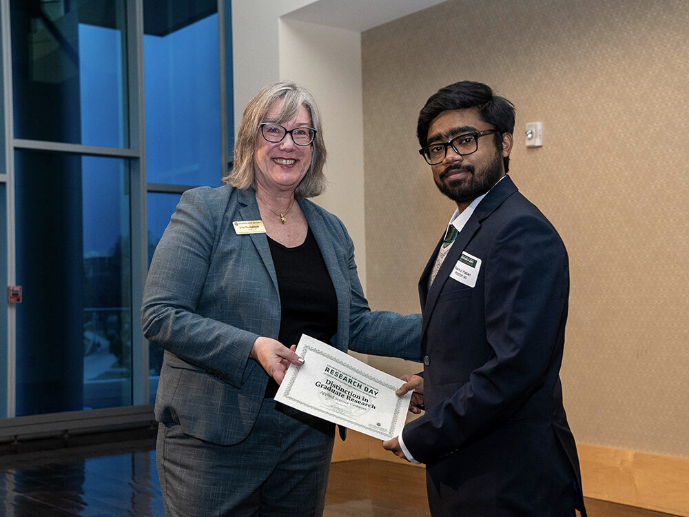 Lise Youngblade presenting Naimul Hasan with the Applied Science - Distinction in Graduate Research award at Research Day 2024