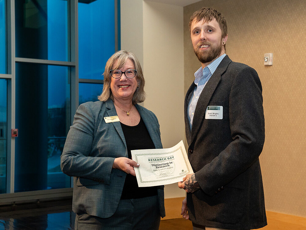 Lise Youngblade presenting Scott Wrigley with the Basic Science - Distinction in Research award at Research Day 2024
