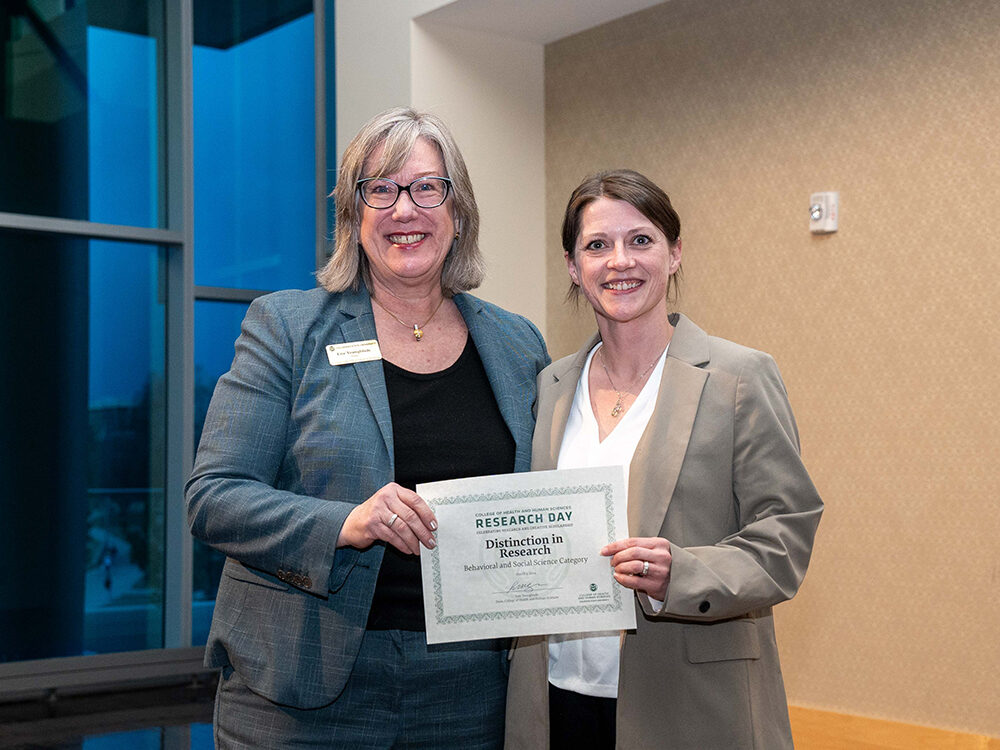 Lise Youngblade presenting Melissa Fenton with the Behavioral and Social Science - Distinction in Research award at Research Day 2024