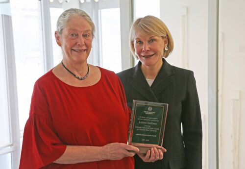Jodie Hanzlik standing with a woman in red who is holding a plaque