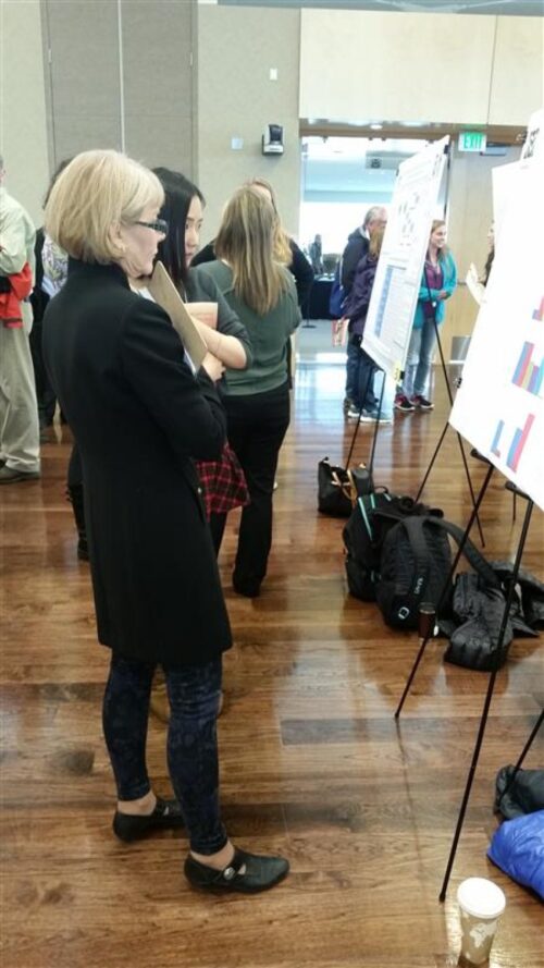 Jodie Hanzlik standing with a student in front of a poster on an easel