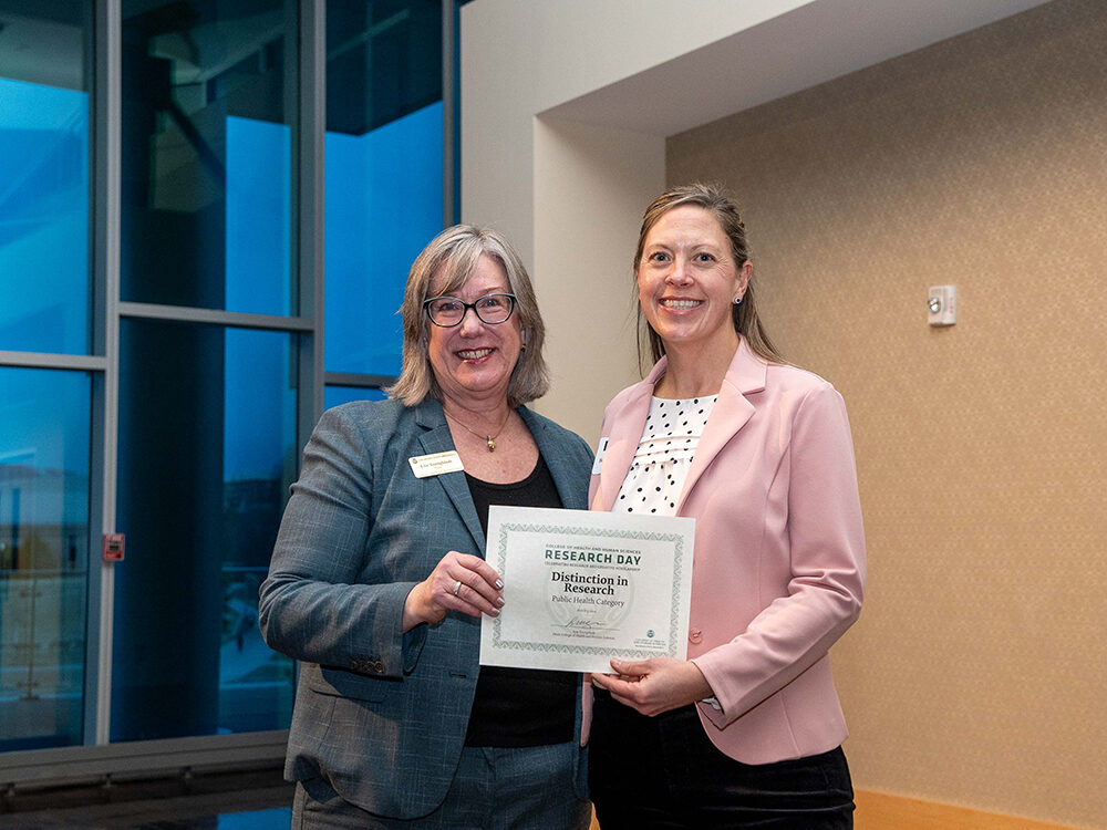 Lise Youngblade presenting Brigid McDonnell with the Public Health Scholarship award at Research Day 2024