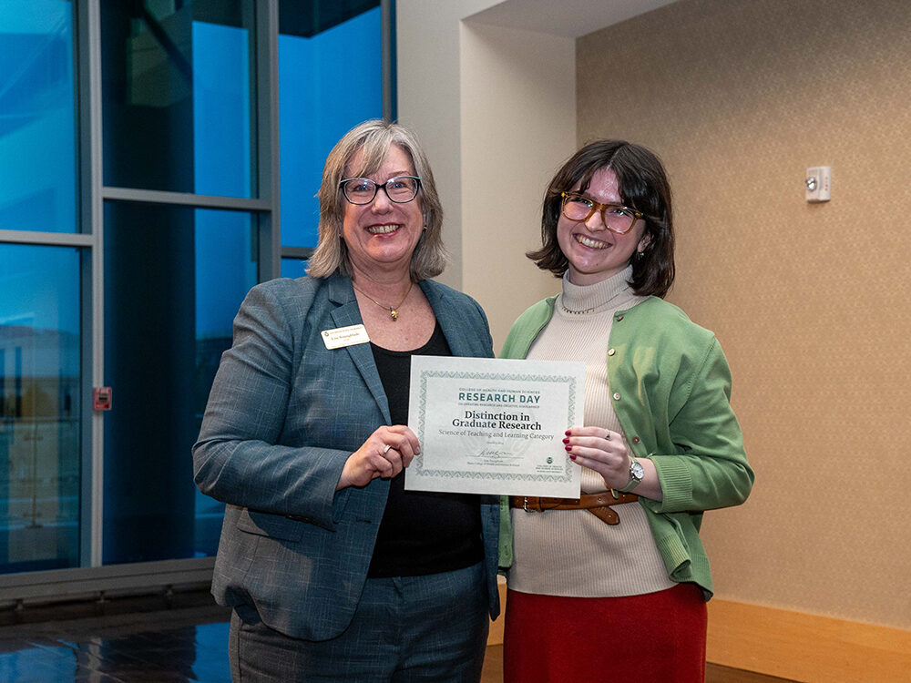 Lise Youngblade presenting Suzie Linihan with the Science of Teaching and Learning - Distinction in Graduate Research award at Research Day 2024