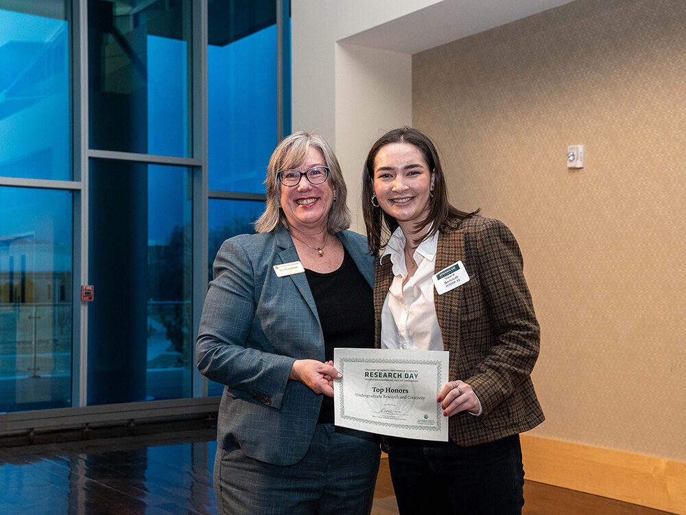 Lise Youngblade presenting Valerie Bortolutti with the Undergraduate Top Honors award at Research Day 2024